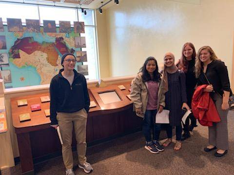 five students in front of a map of Africa at the Arab American Museum